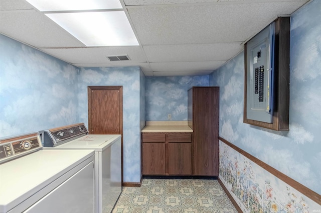 clothes washing area with light floors, visible vents, wallpapered walls, cabinet space, and washer and dryer