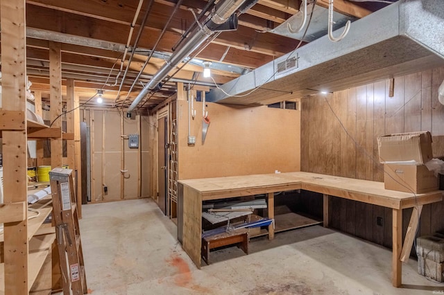 unfinished basement featuring a workshop area and wood walls