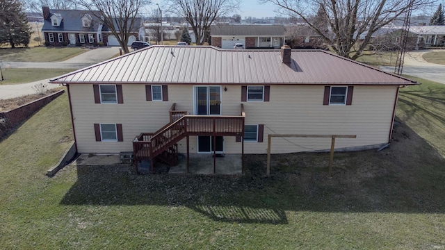 rear view of property with a patio, stairs, a yard, metal roof, and a chimney