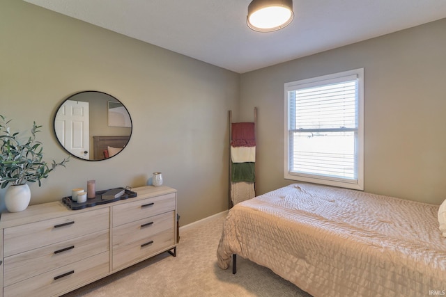 bedroom with light carpet and baseboards