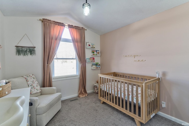 carpeted bedroom featuring a sink, a crib, baseboards, and vaulted ceiling