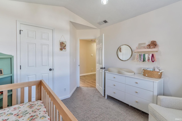 carpeted bedroom featuring visible vents, baseboards, and vaulted ceiling