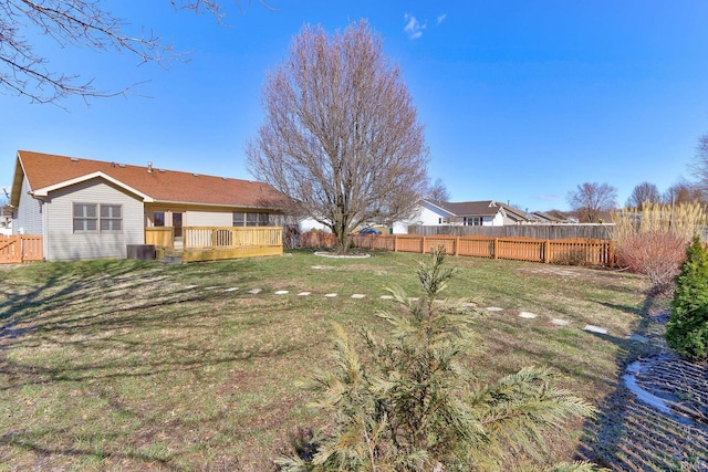 view of yard featuring central AC unit, a wooden deck, and a fenced backyard