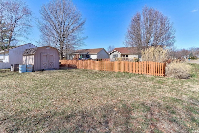 view of yard with a residential view, an outdoor structure, a shed, and fence