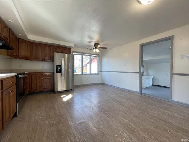 kitchen featuring electric range, wood finished floors, stainless steel fridge with ice dispenser, and light countertops