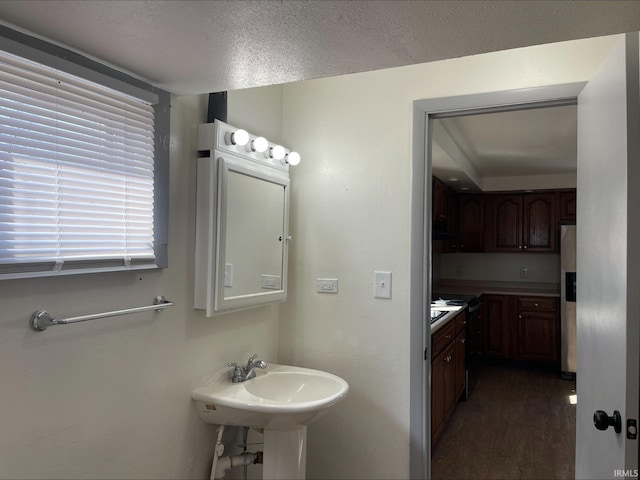 bathroom with a textured ceiling and wood finished floors