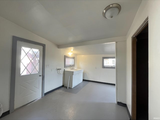 interior space featuring baseboards and a sink