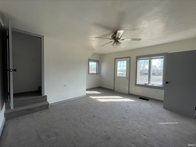 unfurnished bedroom featuring visible vents, baseboards, light colored carpet, and ceiling fan