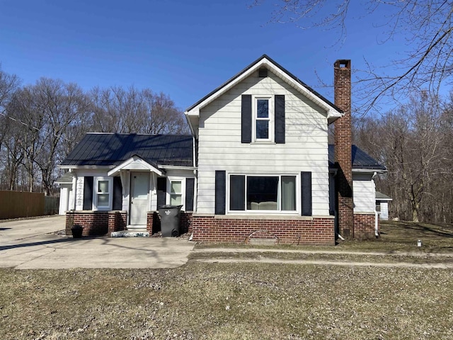 traditional-style home featuring brick siding and a chimney