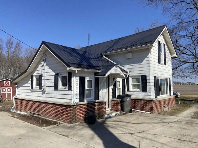 view of front facade with brick siding and metal roof