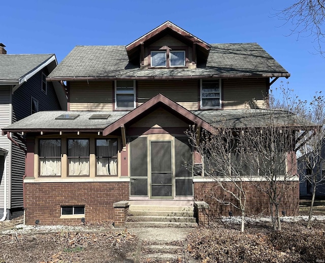 back of property featuring entry steps, brick siding, and a sunroom