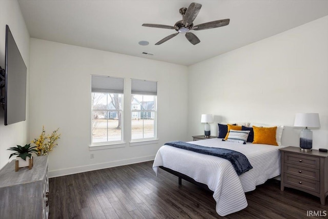 bedroom with dark wood finished floors, baseboards, visible vents, and ceiling fan