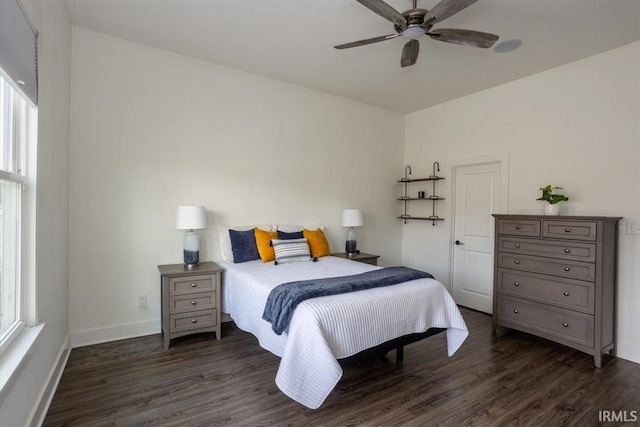 bedroom with dark wood finished floors, a ceiling fan, and baseboards