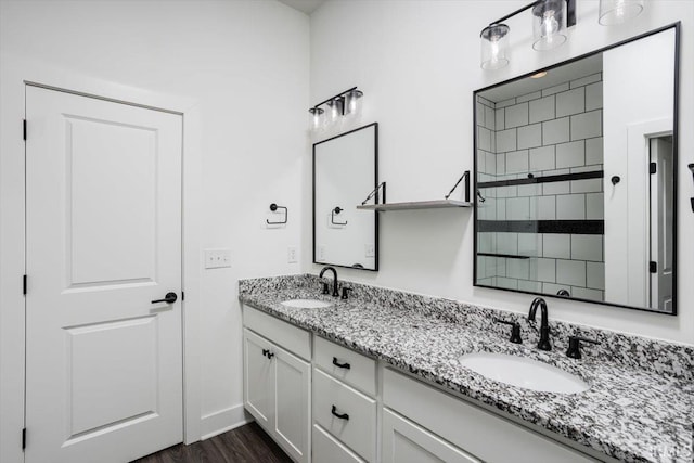 bathroom featuring a sink, wood finished floors, and double vanity