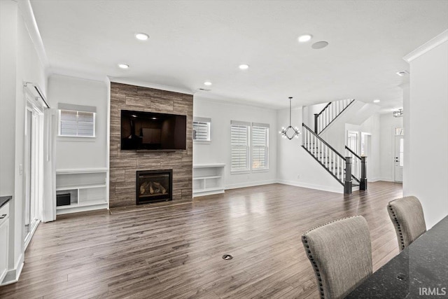 living room featuring stairway, wood finished floors, and ornamental molding