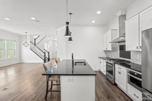 kitchen featuring a sink, dark wood-type flooring, appliances with stainless steel finishes, a kitchen bar, and backsplash