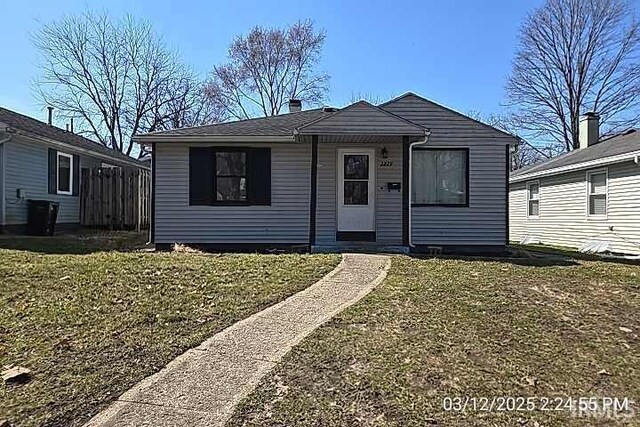 bungalow featuring a front lawn