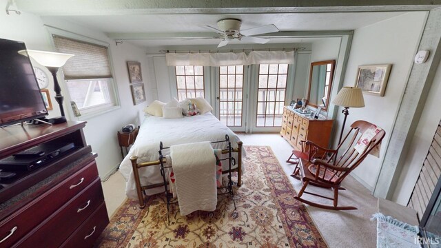 bedroom featuring light carpet, beam ceiling, and multiple windows