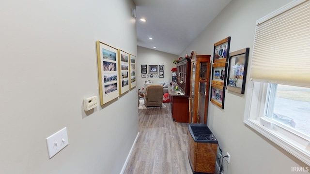 hallway with recessed lighting, baseboards, light wood-type flooring, and lofted ceiling