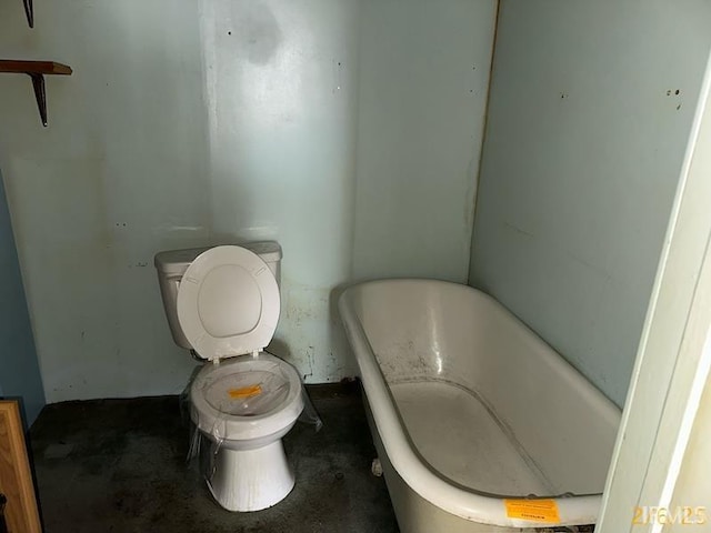 bathroom featuring a freestanding tub and toilet