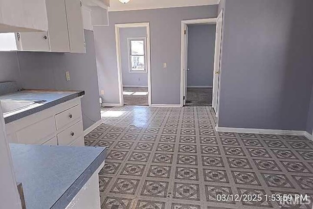 kitchen with white cabinets and baseboards