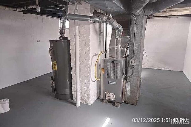 utility room featuring water heater and heating unit