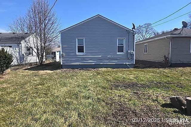 view of side of property with a lawn and fence