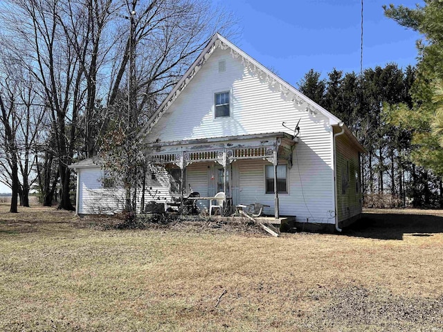 back of property featuring a porch and a yard