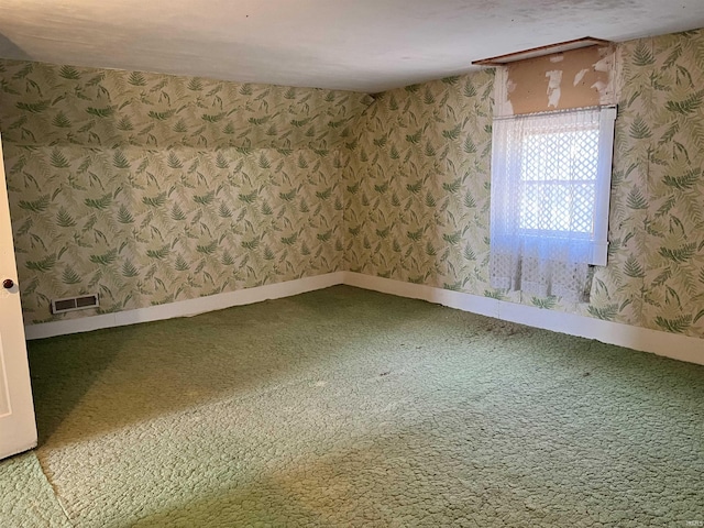 unfurnished room featuring visible vents, baseboards, carpet flooring, and wallpapered walls