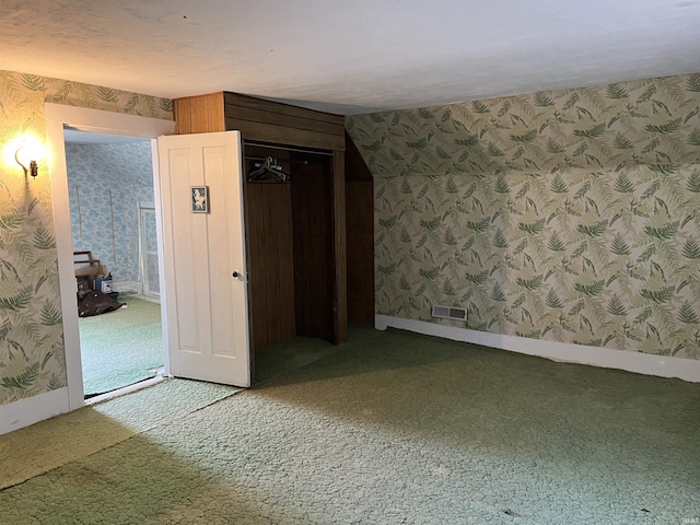 unfurnished bedroom featuring visible vents, a closet, carpet floors, wallpapered walls, and baseboards