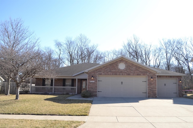 ranch-style home with a front yard, driveway, a porch, an attached garage, and brick siding