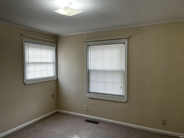 carpeted empty room featuring baseboards, visible vents, and ornamental molding