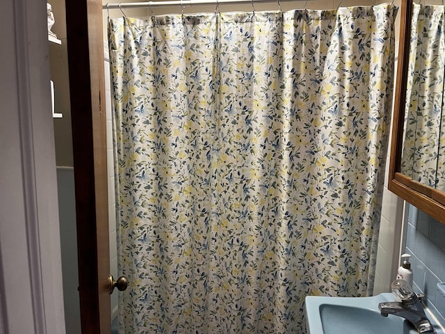 bathroom featuring a shower with curtain and a sink