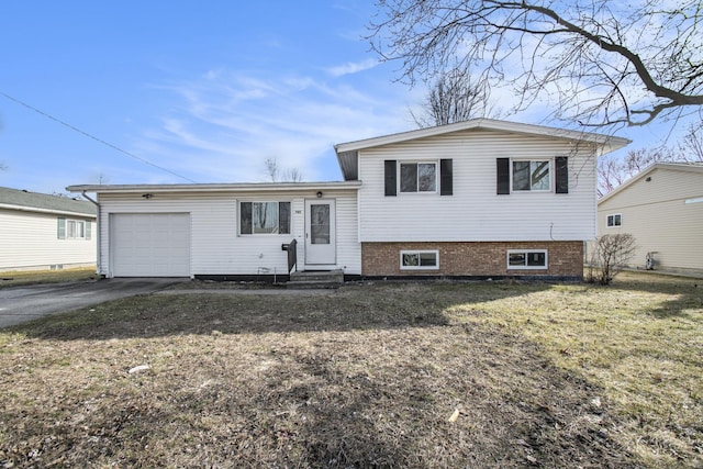 tri-level home featuring entry steps, a garage, and driveway