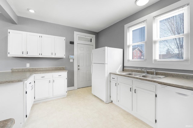 kitchen featuring a sink, white appliances, light floors, and white cabinets