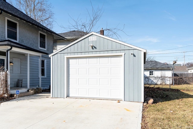 detached garage with concrete driveway and fence