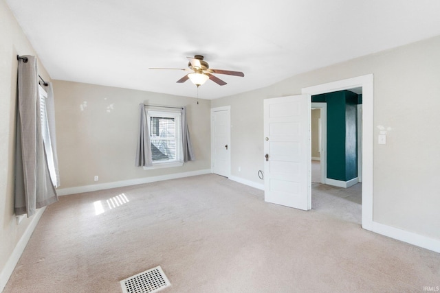 spare room with light carpet, visible vents, ceiling fan, and baseboards