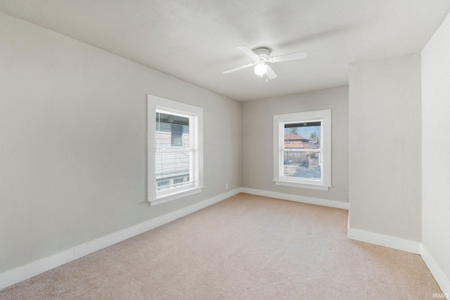 unfurnished room with light carpet, plenty of natural light, and baseboards