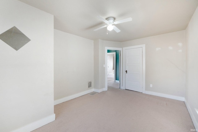 empty room with baseboards, light carpet, and visible vents