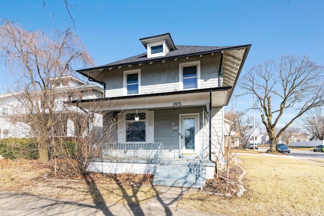 american foursquare style home featuring a porch