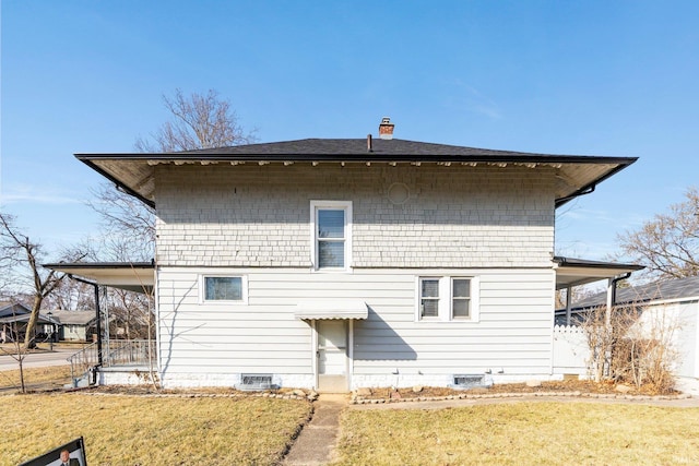 back of house with a carport, crawl space, a chimney, and a yard