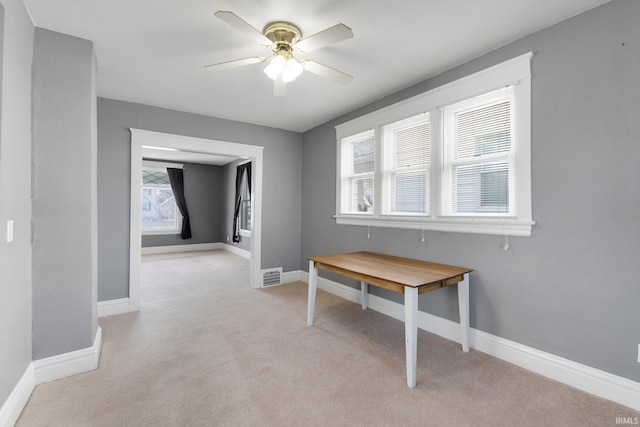 dining area with a ceiling fan, visible vents, light colored carpet, and baseboards