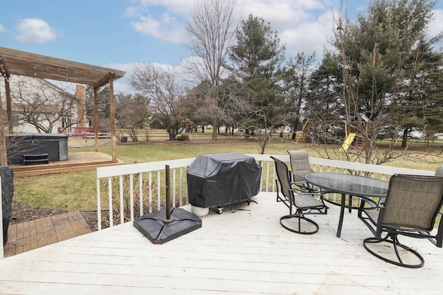 wooden terrace featuring grilling area, outdoor dining area, a yard, and a hot tub