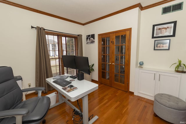 office featuring wood finished floors, visible vents, french doors, and ornamental molding