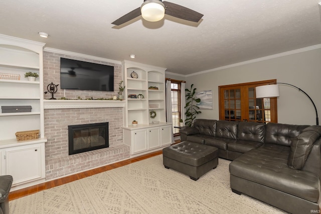 living room featuring a textured ceiling, wood finished floors, a fireplace, and crown molding