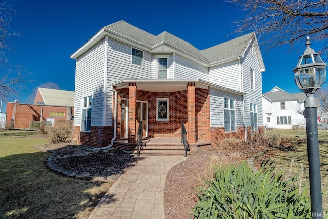 view of front of home featuring brick siding and a front lawn