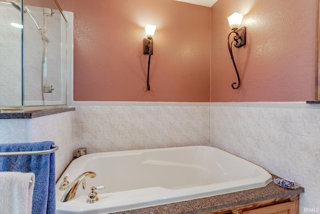 bathroom featuring a bath and a tile shower