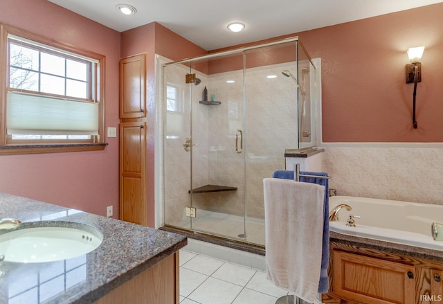 full bathroom with vanity, a shower stall, a garden tub, and tile patterned floors