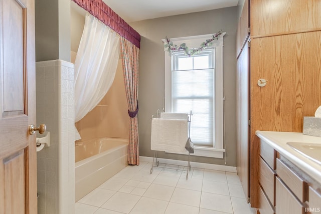 bathroom featuring tile patterned floors, vanity, shower / bath combo with shower curtain, and baseboards