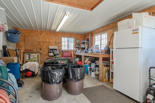 garage with a workshop area and freestanding refrigerator